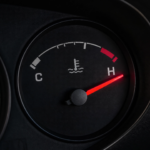 car dashboard with the temperature gauge needle in the red zone