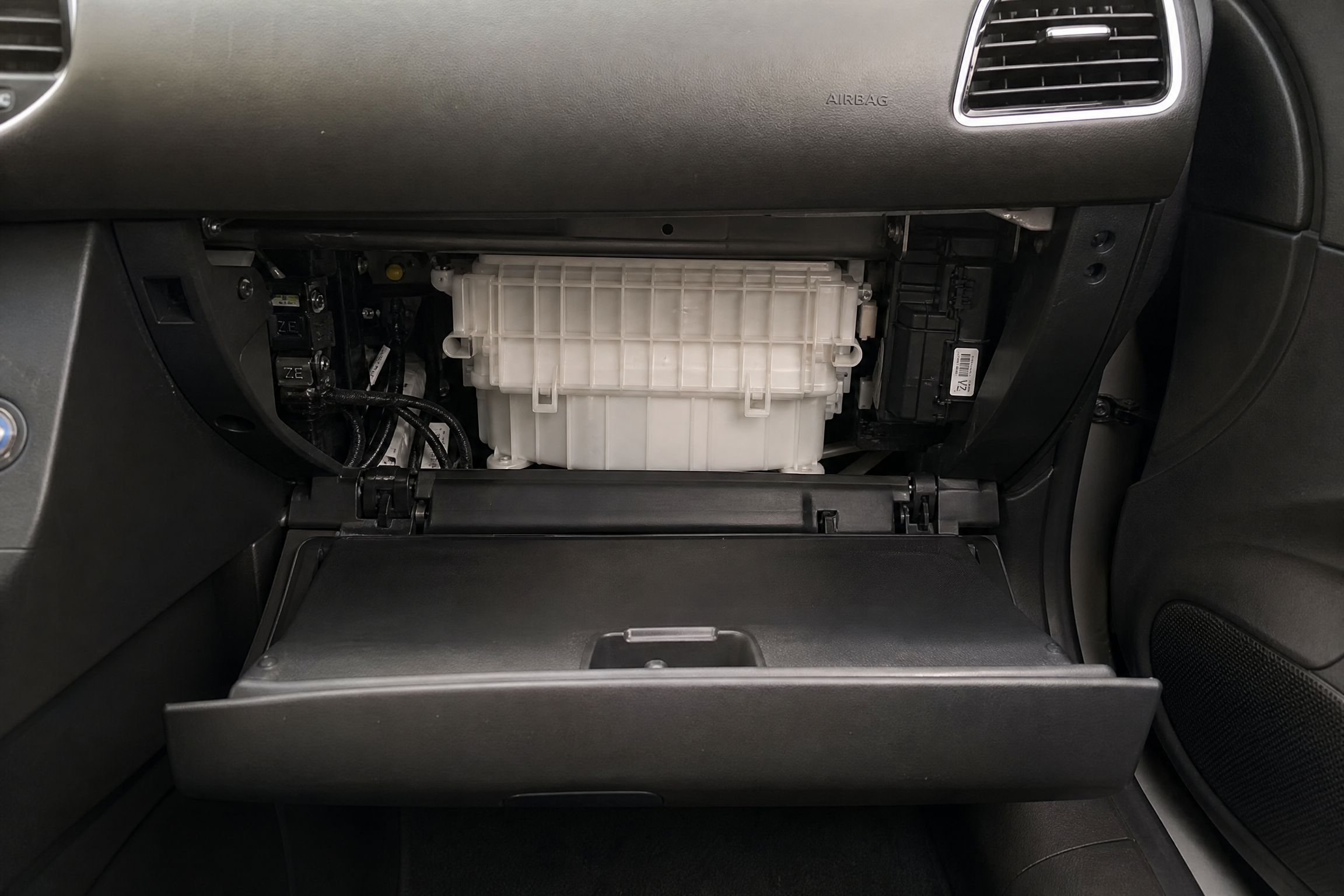 Dirty gray cabin air filter covered in leaves and debris next to a clean white one