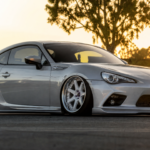 Lowered sports car with upgraded suspension at golden hour
