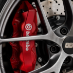 High performance red brake caliper and drilled rotor behind alloy wheel